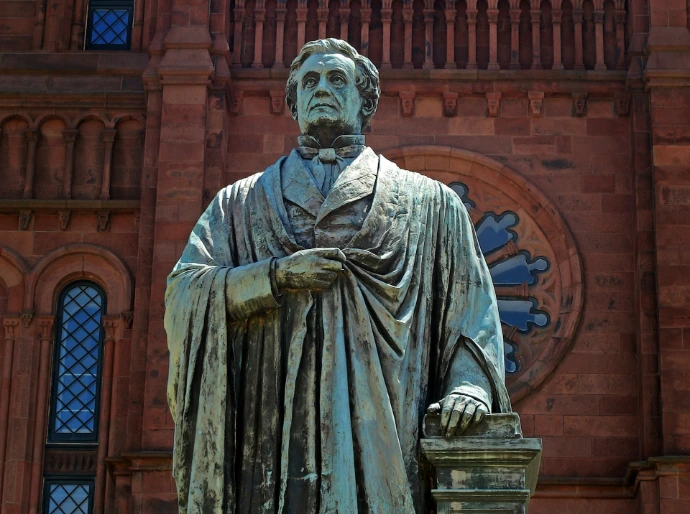 A statue of a man holding a bucket in front of a building